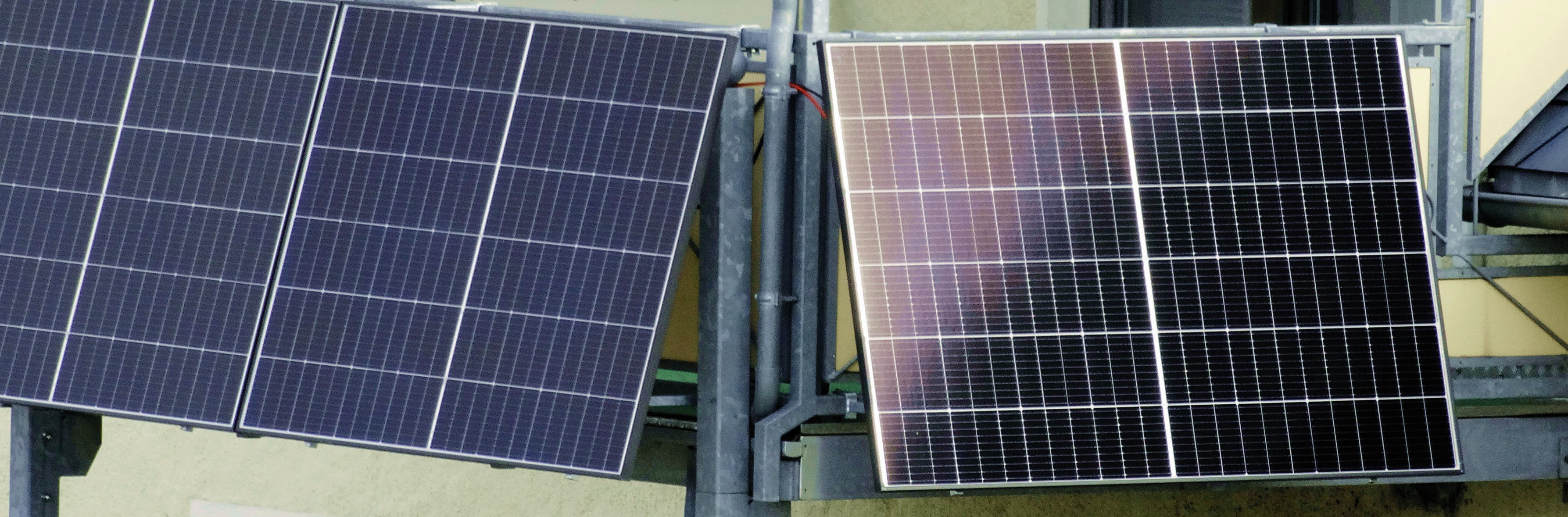 Foto einer Photovoltaikanlage am Balkongeländer eines Merhfamilienhauses